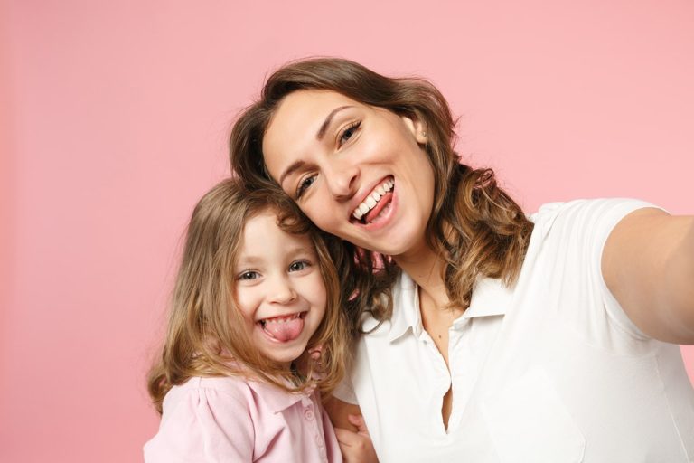 mom selfie with kid on pink background